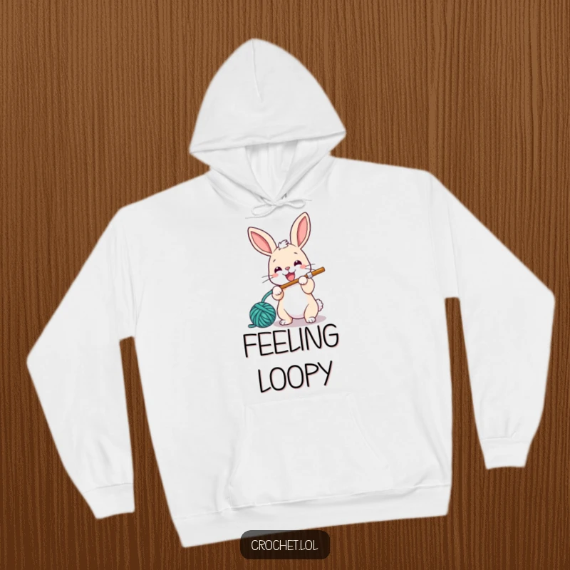 Funny hoodie featuring a small, energetic bunny with a crochet hook, happily looping yarn, designed for ultimate comfort and fun.