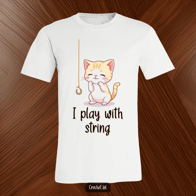 Funny t-shirt illustration of a tiny, curious cat intently playing with a dangling thread hooked onto a crochet hook, full of playful energy.